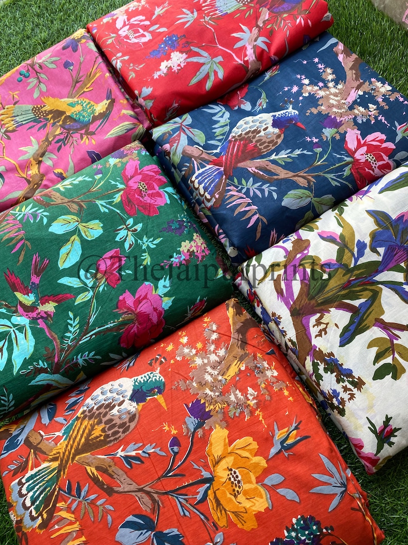 Op de afbeelding: Zes verschillende stofstalen met bloemen- en vogelmotieven. De stoffen zijn in verschillende kleuren, waaronder rood, roze, groen, blauw en oranje. De patronen tonen vogels, bloemen en bladeren.