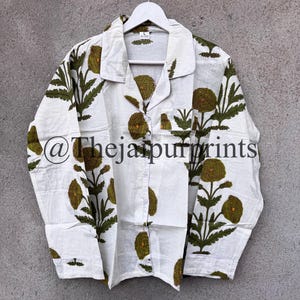 May include: White button-down pajama set with a green floral pattern. The long-sleeved shirt has a notched collar, a chest pocket, and the text "@Thejaipurprints". The floral design features large, round flowers and leafy stems.
