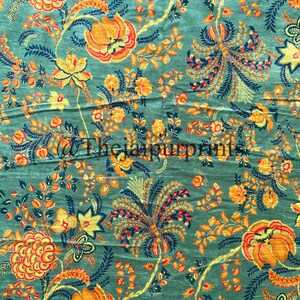 May include: A teal fabric with a floral pattern in shades of yellow, orange, and red. The flowers are stylized and have a vintage feel.