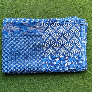 以下が含まれることがあります： 青と白の幾何学模様の生地。生地は半分に折り畳まれており、わずかに質感のある表面をしています。