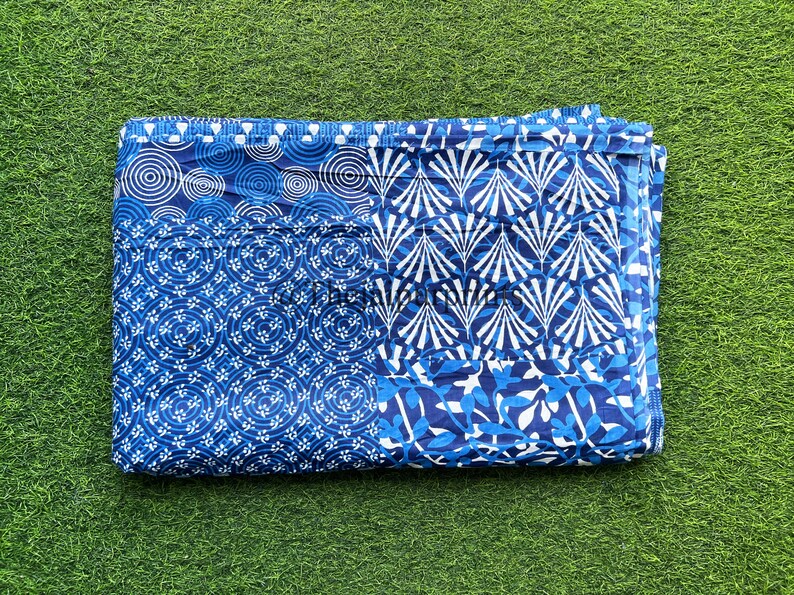 以下が含まれることがあります： 青と白の幾何学模様の生地。生地は半分に折り畳まれており、わずかに質感のある表面をしています。