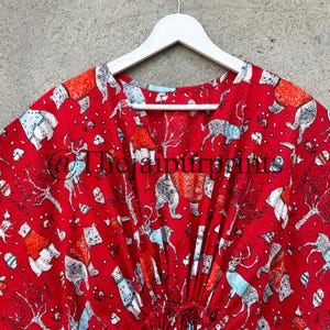 May include: Red cotton kaftan with a drawstring waist and a print of various animals wearing sweaters. The animals include bears, deer, and foxes.