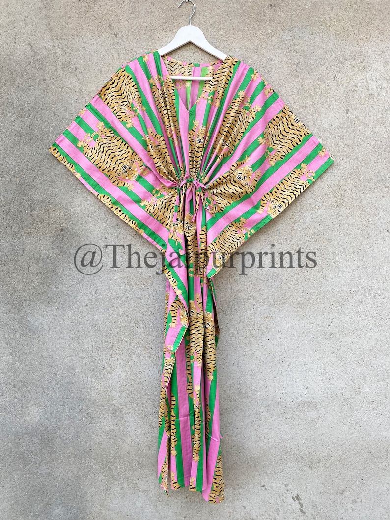 May include: A pink and green striped kaftan with a tiger print design. The kaftan has a V-neck and a drawstring waist. The text "@Thejaipurprints" is visible in the bottom left corner.