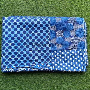 以下が含まれることがあります： 青と白の綿生地で、パッチワークのデザインになっています。生地には、水玉模様、同心円模様、繰り返し涙模様の3つの異なるパターンがあります。