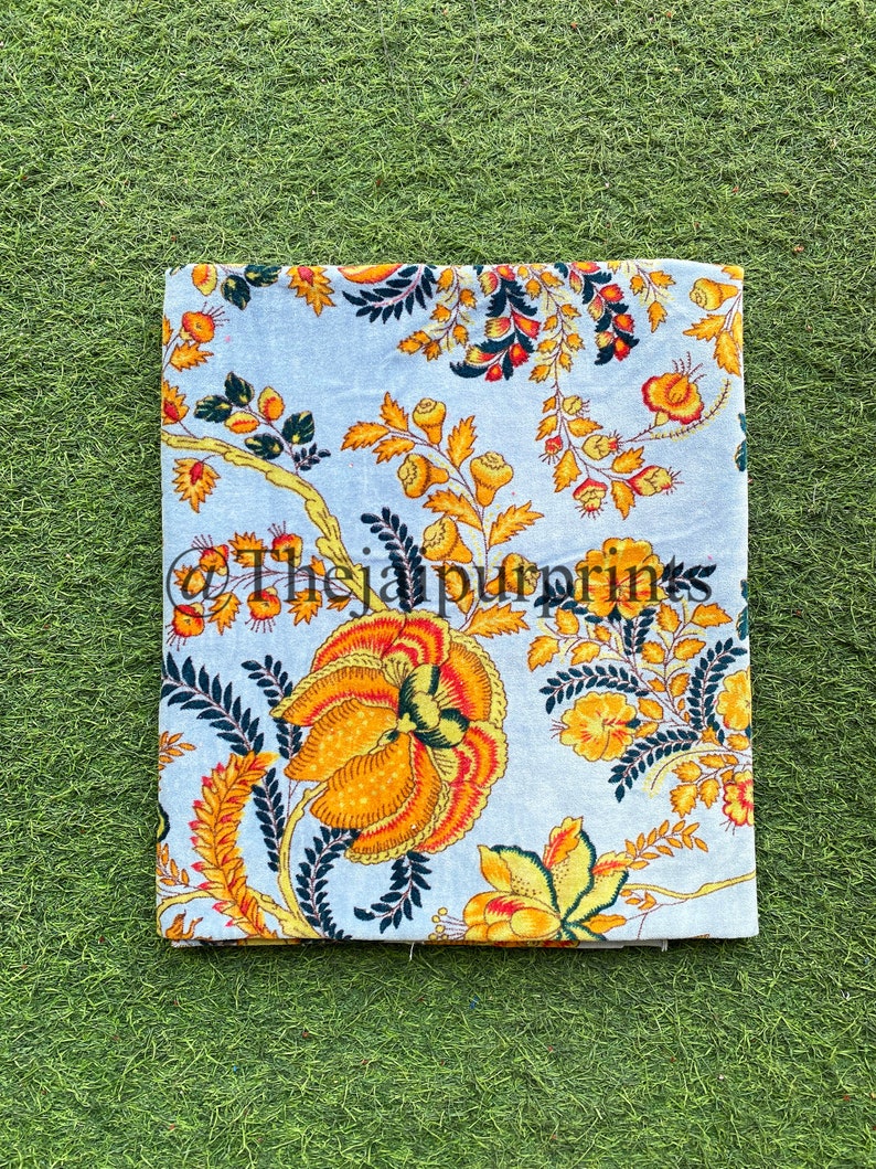 May include: A light blue fabric with a floral pattern in shades of yellow, orange, and green. The fabric has a vintage feel and is perfect for crafting projects.