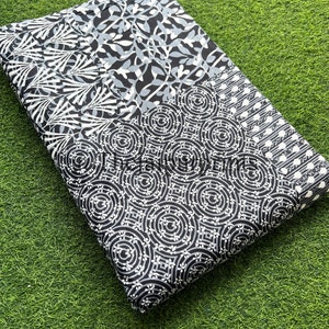 以下が含まれることがあります： 黒と白の生地で、パッチワークのデザインが施されています。円形、葉、ストライプなど、さまざまなパターンが特徴です。