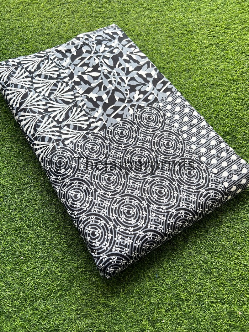 以下が含まれることがあります： 黒と白の生地で、パッチワークのデザインが施されています。円形、葉、ストライプなど、さまざまなパターンが特徴です。