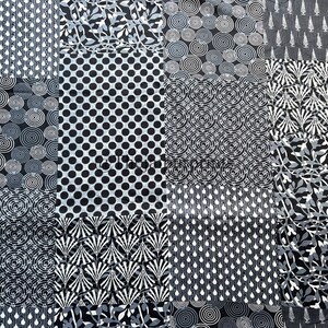 以下が含まれることがあります： 黒と白のパッチワークデザインの布。布には、円、ドット、葉など、さまざまな幾何学模様が施されています。