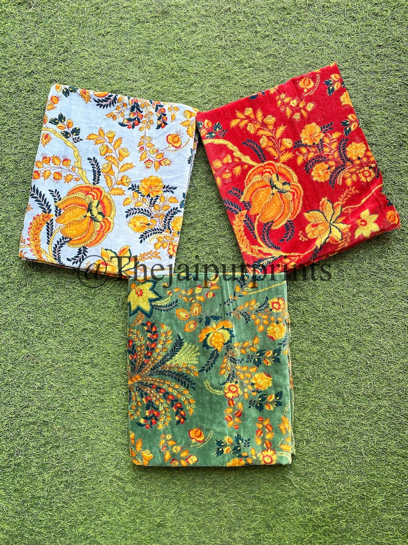 May include: Three fabric squares with floral patterns. The squares are in shades of red, green, and white with yellow floral designs.