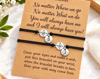 May include: Two black cord bracelets attached to a tan card. Each bracelet features a silver-toned compass charm and a circular charm with the letters D or J. The card displays the text: Wish Bracelet, No matter Where we go, No matter What we do, You will always have me and I will always have you! Close your eyes and make a wish, put this bracelet on your wrist, when the bracelet breaks in two, then your wish may come true.