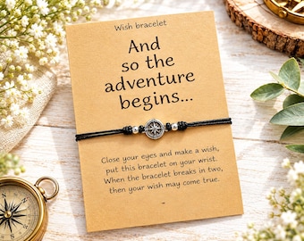 May include: A black cord wish bracelet featuring a small silver-toned compass charm and two silver beads, mounted on a tan card printed with the text: Wish bracelet, And so the adventure begins, Close your eyes and make a wish.