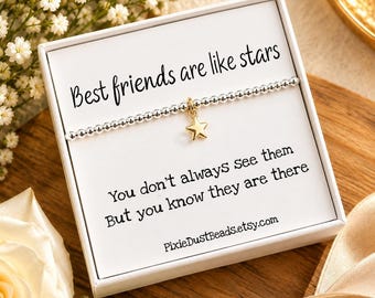 May include: A silver beaded bracelet with a small gold star charm centered in a white gift box. The card inside reads: Best friends are like stars. You don't always see them. But you know they are there. PixieDustBeads.etsy.com.