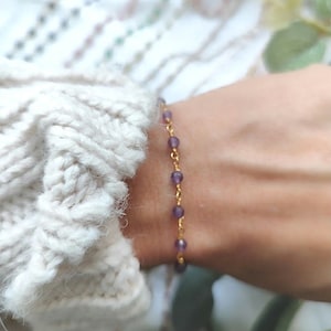 Op de afbeelding: Een delicate gouden kettingarmband met kleine paarse amethist kralen.