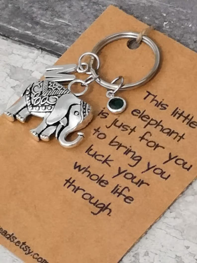 Pu&ograve; includere: Un ciondolo a forma di elefante d'argento con dettagli intricati &egrave; appeso a un portachiavi d'argento con un ciondolo di pietra preziosa verde. Il ciondolo &egrave; attaccato a una carta marrone con il testo "Questo piccolo elefante &egrave; solo per te per portarti fortuna per tutta la vita."