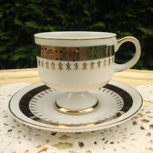 Footed white teacup with gold decorations