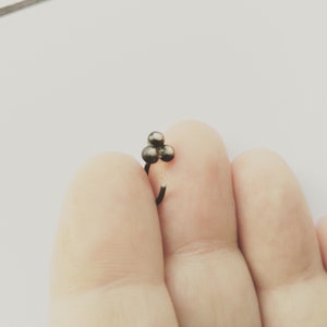 以下が含まれることがあります： 3つの丸いビーズが付いた小さなシルバーの鼻のリング