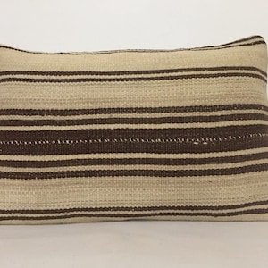 May include: A brown and white striped throw pillow with a woven texture.