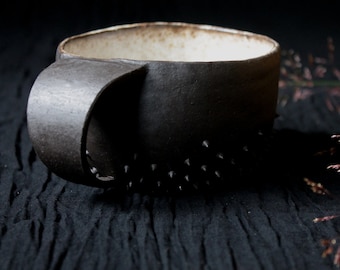 rustic cup with spikes made of black ceramic