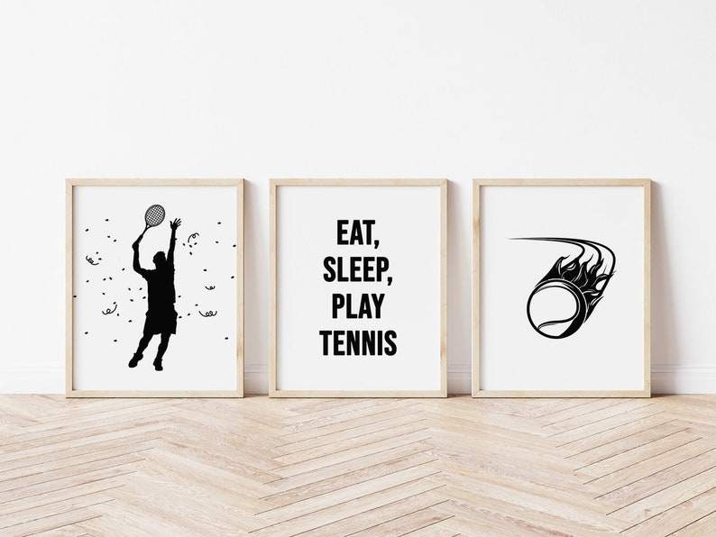 Pu&ograve; includere: Tre stampe incorniciate a tema tennis. La stampa a sinistra mostra una silhouette nera di un giocatore di tennis. La stampa centrale ha le parole "EAT, SLEEP, PLAY TENNIS" in nero. La stampa a destra presenta una palla da tennis con fiamme.