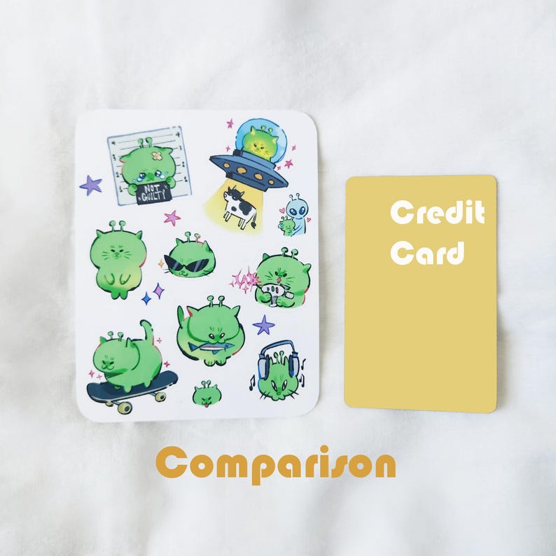 May include: A white sticker sheet featuring various green alien illustrations with different expressions and activities. One alien is in a spaceship, another is skateboarding, and one is wearing headphones. The text "NOT GUILTY" is also present.