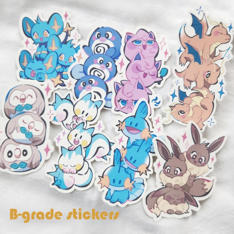 Puede incluir: Una colecci&oacute;n de pegatinas troqueladas y coloridas con varias criaturas de dibujos animados. Las pegatinas muestran una variedad de dise&ntilde;os, incluyendo personajes azules, rosas y marrones. El texto "B-grade stickers" es visible en la parte inferior.