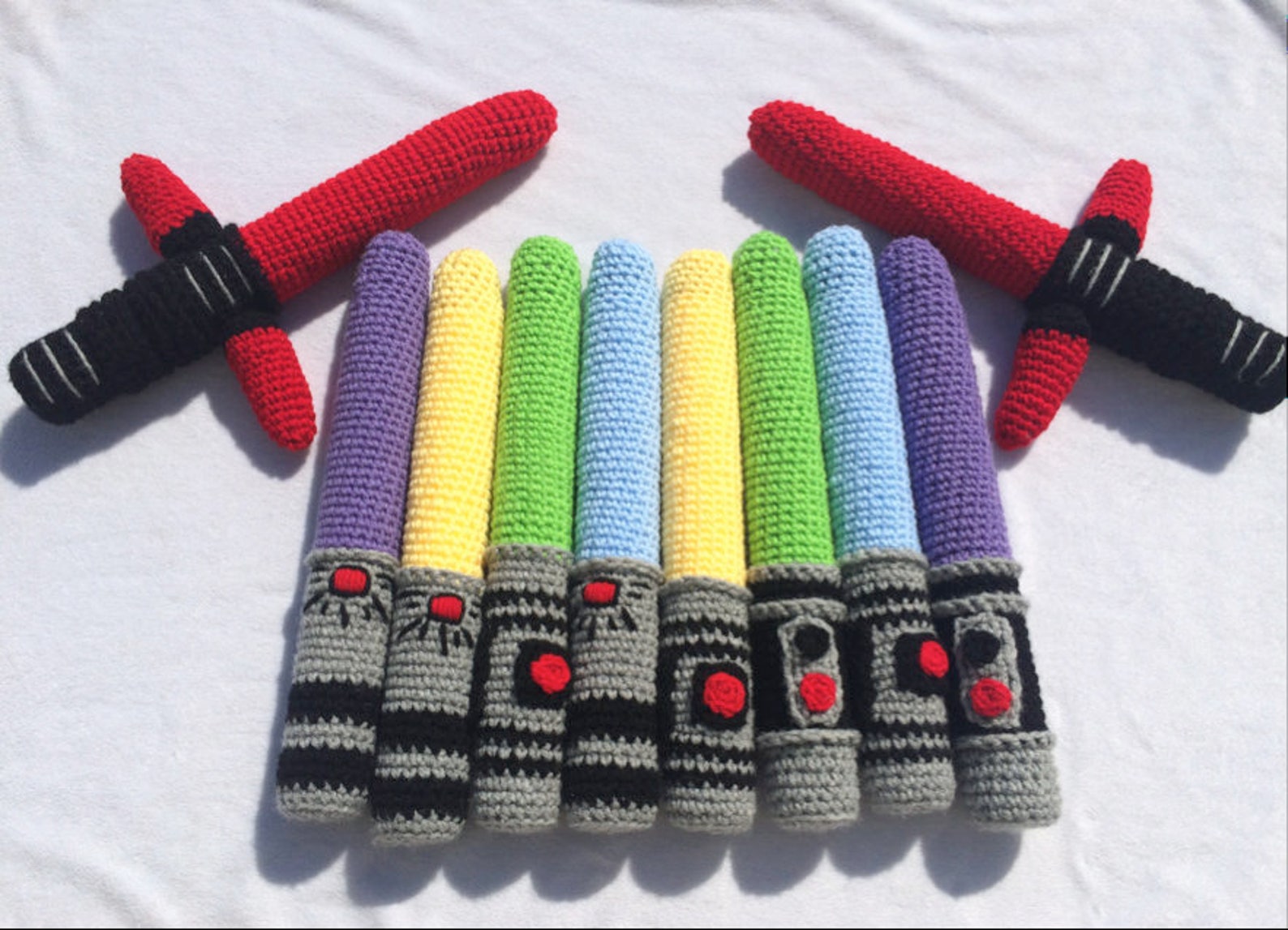 Crochet Lightsaber Pattern Handmade crochet lightsaber toys in bright red, blue, and green yarn, perfect for imaginative play.