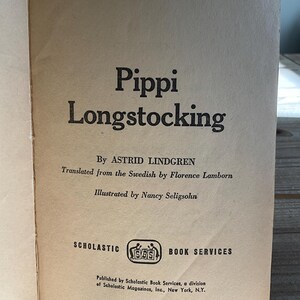 Może przedstawiać: Otwarta strona książki z tytułem "Pippi Longstocking" pogrubioną czcionką. Wymieniono r&oacute;wnież autora, tłumacza i ilustratora. Widoczne jest logo Scholastic Book Services. Strona ma wygląd vintage, postarzaną.