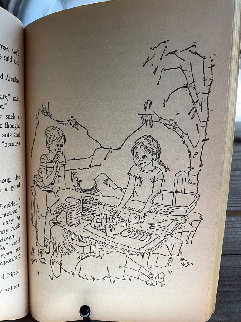 Może przedstawiać: Czarno-biała ilustracja z książki dla dzieci przedstawiająca scenę piknikową. Dwoje dzieci siedzi w pobliżu kosza piknikowego i jedzenia, a trzecie dziecko leży. W tle drzewo i g&oacute;ra.