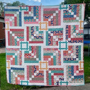 May include: A patchwork quilt with a white background and squares of red, blue, and green fabric. The squares are arranged in a geometric pattern, creating a modern and stylish design.