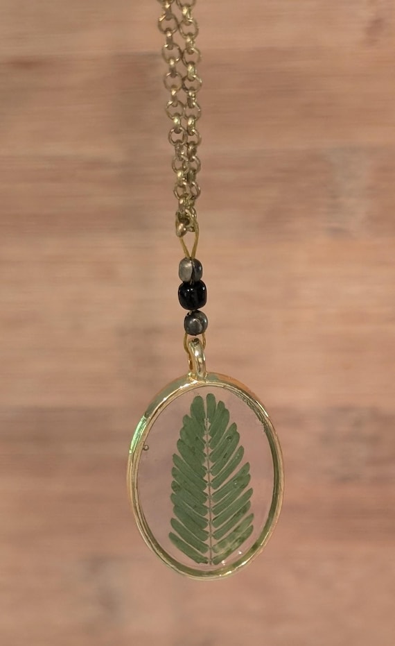 FEUILLE DE MIMOSA: Statement pendant with authentic botanicals (Mimosa leaf) and resin. Bronze tone.