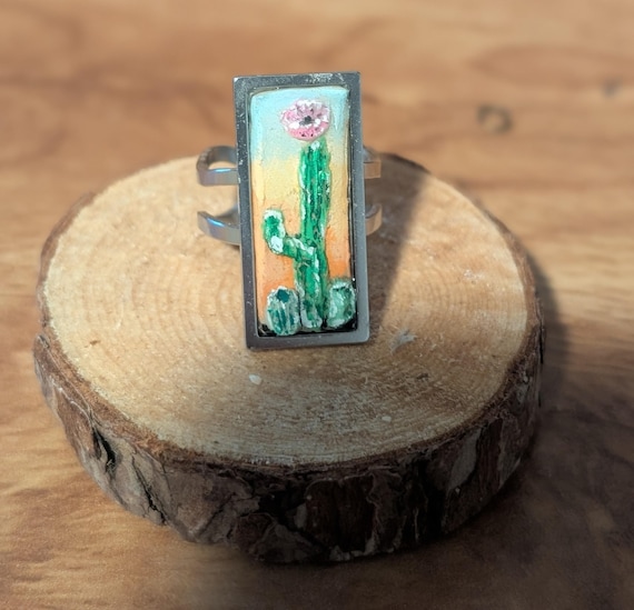 Dessert Flower: Handmade jewelry- carved and painted clay and resin statement ring. Cactus, flower, and sunset, silver-tone setting.