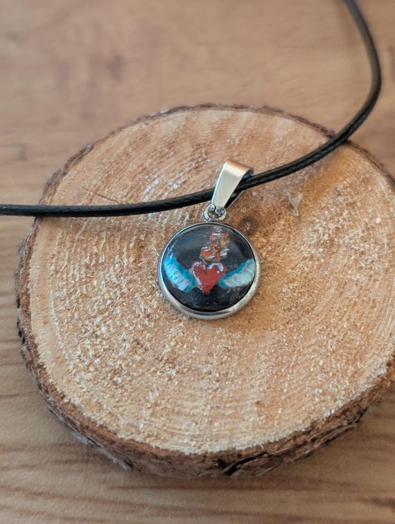 Flamming Heart: Hand-carved and painted clay and resin pendant. Handmade jewelry. Flamming sacred heart with wings. Stainless.