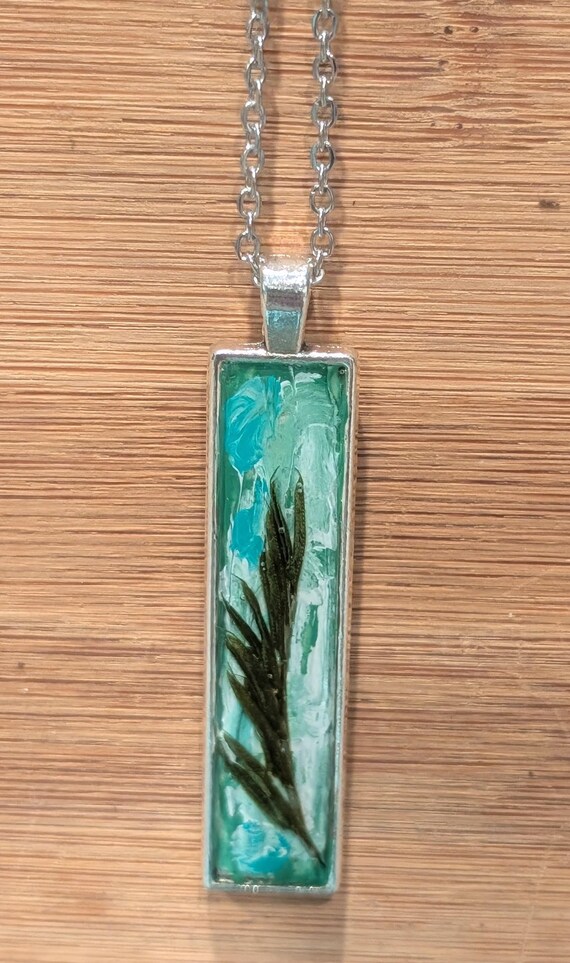 NATURE'S FLARE: Statement pendant with authentic botanicals, pigment, and resin.  Silver tone.