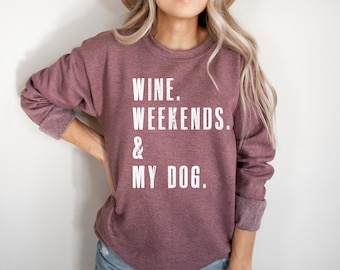Puede incluir: Una sudadera color granate con el texto "WINE. WEEKENDS. & MY DOG." impreso en blanco.