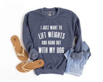 May include: A navy blue sweatshirt with the text "I just want to lift weights and hang out with my dog" in white.
