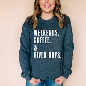 K&ouml;nnte beinhalten: Ein dunkelblauer Pullover mit dem Aufdruck "Weekends. Coffee. & River Days." in wei&szlig;.