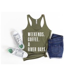 Puede incluir: Una camiseta sin mangas verde con el texto "Weekends. Coffee. & River Days." impreso en blanco. La camiseta sin mangas est&aacute; fotografiada sobre un fondo blanco con un par de zapatillas blancas y unos pantalones cortos de mezclilla azul.