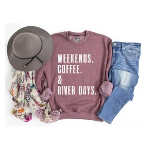 K&ouml;nnte beinhalten: Ein mauvefarbenes Sweatshirt mit dem Aufdruck "Weekends. Coffee. & River Days." in Wei&szlig;.