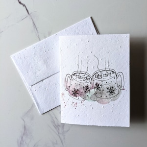 Enveloppe de carte à planter graines de fleurs sauvages, tasses de chocolat chaud de Noël sur papier blanc de graines de fleurs sauvages, papier à planter, carte de Noël