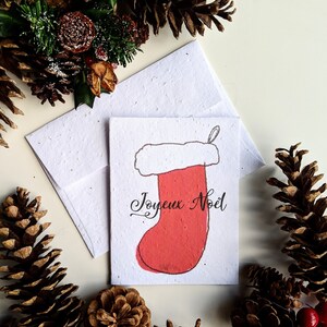 Enveloppe de carte de Noël à planter graines de fleurs sauvages, bas rouge joyeux Noël sur papier de graines de fleurs sauvages blanc, joyeux Noël