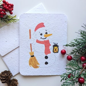 Bonhomme de neige avec un balai sur du papier à planter ou du papier blanc aquarelle, bordures usées