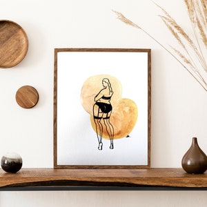May include: A framed illustration of a woman in black lingerie standing on a watercolor background with two large, overlapping circles in shades of gold.