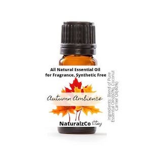 May include: A small amber glass bottle with a black cap, labeled "All Natural Essential Oil for Fragrance, Synthetic Free" and "Autumn Ambience". The label also includes the text "NaturalzCo Etay" and lists the ingredients as a blend of pure essential oils and coconut carrier oil.