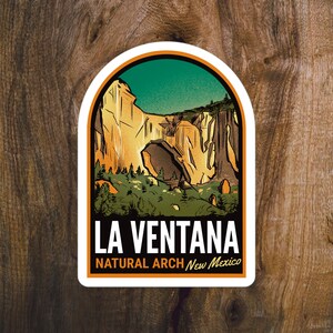 May include: A sticker featuring a landscape illustration of La Ventana Natural Arch in New Mexico. The design includes a natural arch, cliffs, and trees, with the text "LA VENTANA NATURAL ARCH New Mexico" in a bold font. The sticker has a white border.