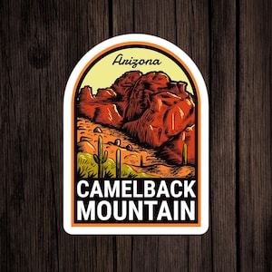 May include: A white sticker with a yellow, orange, and brown illustration of Camelback Mountain in Arizona. The text "Arizona" is at the top of the sticker and "Camelback Mountain" is at the bottom.