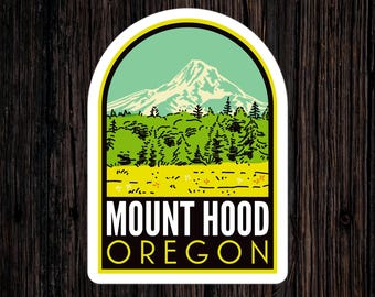 May include: A white sticker with a yellow border features a green and blue illustration of Mount Hood, a mountain in Oregon. The text "MOUNT HOOD OREGON" is printed in black on a yellow background.