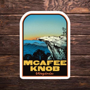 May include: A sticker featuring a scenic illustration of McAfee Knob in Virginia. The design includes a cliff edge, mountains, and a colorful sky. The text "MCAFEE KNOB Virginia" is prominently displayed in yellow and orange.