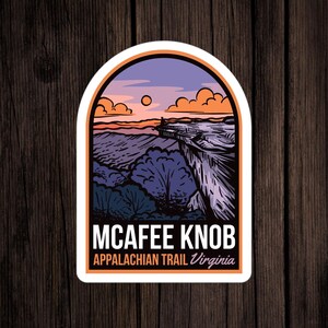 May include: A sticker with a vintage illustration of a mountain range at sunset. The text reads "McAfee Knob Appalachian Trail Virginia".
