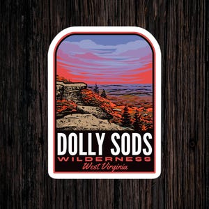 May include: A sticker featuring a scenic view of the Dolly Sods Wilderness in West Virginia. The sticker depicts a rocky cliff with trees and a colorful sunset sky.