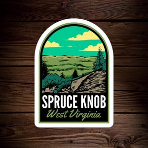 May include: A sticker with a green, yellow, and blue illustration of a mountain landscape with trees and a road. The text "Spruce Knob West Virginia" is printed in white on a black background.